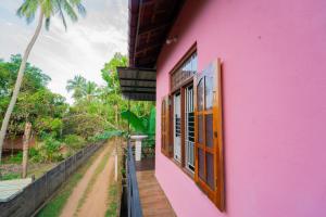 帕西库达Passi CK Homestay的粉红色的房子,享有街道的景色