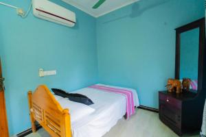 帕西库达Passi CK Homestay的一间蓝色卧室,配有一张床和一个梳妆台