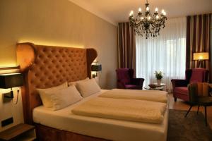奥斯特巴德·哥伦瓦德博丽酒店的酒店客房设有一张大床和吊灯。