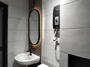 雪邦Urban Inn, Salak Tinggi的一间带水槽和镜子的浴室