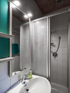滨湖科伊查赫Ferienwohnungen am See Haus Spitzer的一间带水槽、淋浴和镜子的浴室