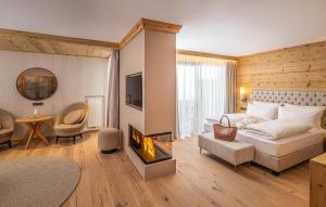 塞尔瓦迪加尔代纳山谷萨沃伊多洛米蒂斯豪华Spa酒店的客厅设有一张床和一个壁炉