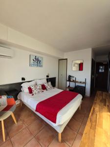 滨海圣西尔尚特普拉奇酒店的一间卧室配有一张带红色毯子的大床