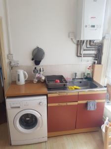 布罗姆利Bromley Cosy的厨房配有洗衣机和水槽