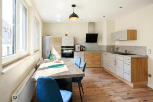 森海姆Ferienwohnung für die Familie, grosse Dachterrasse, Waschmaschine, Trockner的厨房配有木桌和蓝色椅子