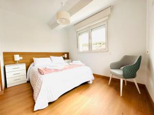 米拉多罗Apartamento San José的卧室配有床、椅子和窗户。
