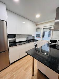 米拉多罗Apartamento San José的厨房配有白色橱柜和黑色台面