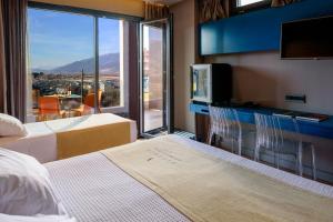 约阿尼纳Essence Hotel的酒店客房设有两张床、一台电视和一扇窗户。