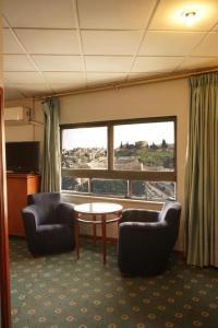 安曼Conord Hotel - "Amman's Heart"的一间设有两把椅子、一张桌子和一个窗户的房间