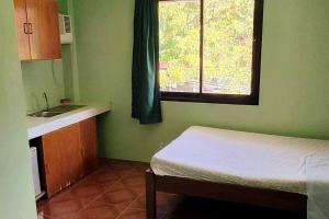 波尔多·格尼拉Melon House Maliit的一间卧室配有床、水槽和窗户