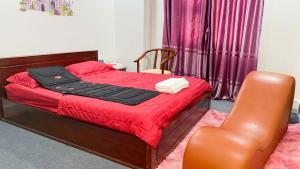 潘切A64 Love Hotel的一间卧室配有一张带红色毯子和椅子的床