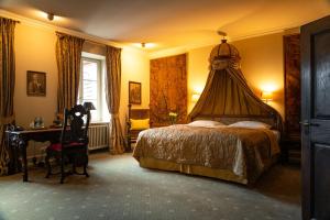 洛马尔Schloss Auel Boutique Hotel & Design Golf Lodge的一间卧室配有一张床和一张书桌