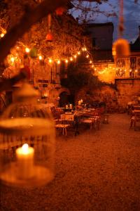 艾瓦勒克马卡龙科纳基旅馆的餐厅设有灯光、桌子和蜡烛
