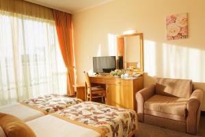 阳光海滩Hotel Wela - Premium All Inclusive的酒店客房配有一张床和一张带镜子的书桌