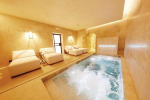 巴勒莫Casa Nostra Boutique Hotel & Spa的一个带沙发和椅子的房间的游泳池