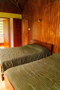 罗索Roxy's Mountain Lodge的卧室设有2张床和木镶板