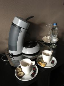 尼乌波特B&B De Kaai的咖啡壶和桌子上的两杯咖啡