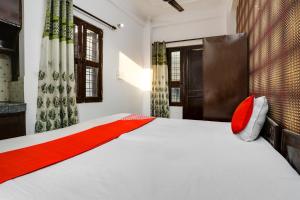 古尔冈OYO Flagship Corporate House的卧室配有带红色枕头的白色床