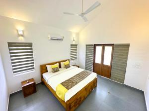 维特利Tarang Holiday Homes的一间卧室配有一张床和吊扇