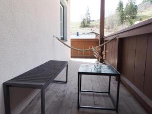 霍赫克尼希山麓丁滕Leni`s Mountain Appartements的阳台设有长凳、桌子和窗户。