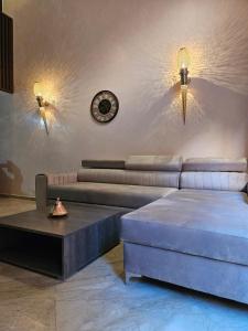 马拉喀什Charmant duplex au cœur de gueliz, quartier haut de gamme de Marrakech的带沙发、桌子和时钟的客厅