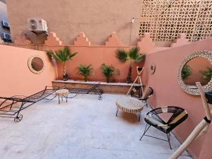马拉喀什Charmant duplex au cœur de gueliz, quartier haut de gamme de Marrakech的一座带桌椅的庭院和一座建筑