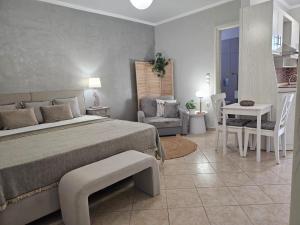 雷夫科斯卡尔帕索Le Grand Bleu Studios & Apartments的卧室配有1张床、1张桌子和1把椅子