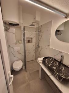 巴尔Apartmani Emma Dobre Vode的一间带卫生间和玻璃淋浴间的浴室