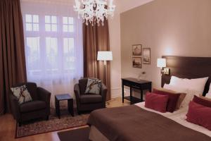 卡尔斯塔德克拉丽奥德罗特连锁酒店的一间卧室配有一张床、两把椅子和一个吊灯