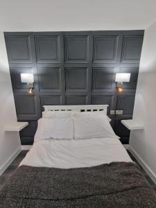 达特福德Delightful cabin retreat wrapped by natural beauty的卧室配有一张带两个灯的大白色床
