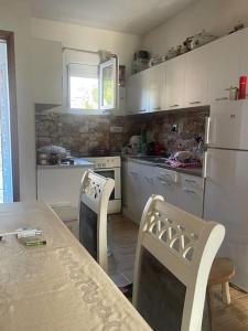 NjegušiKadmi的厨房配有桌椅和白色冰箱。