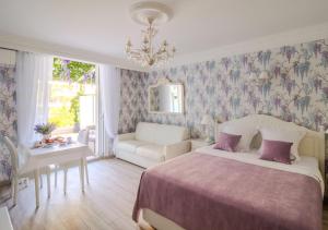 戛纳Cannes Imperial Croisette Palais Miramar的一间卧室配有一张床、一张沙发和一张桌子