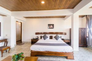 甘托克Sparrow Cherry Resort Near MG Marg的一间卧室设有一张大床和木制天花板