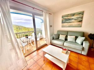 卡拉圣维森特Apartamento en Ibiza的带沙发的客厅和阳台