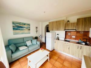 卡拉圣维森特Apartamento en Ibiza的带沙发的客厅和厨房