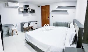 Ban Nong WaengS&Y Apartment的白色卧室配有床和桌椅