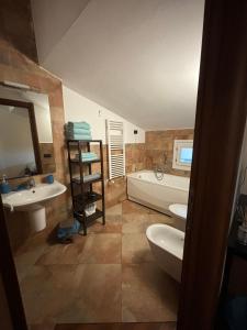佛罗伦萨Vespucci Rooms & Apartament Eliana SELF CHECK-IN的带浴缸、两个盥洗盆和浴缸的浴室。
