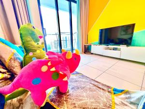 努沙再也Legoland-Happy Wonder Love Suite-Elysia- Max8pax-with Garden-Pool view的客厅配有粉红色的大象和电视