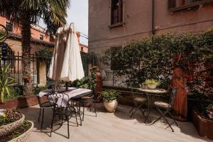 威尼斯艾尔格雷奇奢华公寓的庭院配有遮阳伞和桌椅。