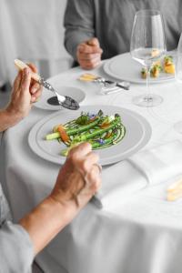圣耐克森La Chartreuse du Bignac - Teritoria的两个人坐在桌子上,拿着一盘食物