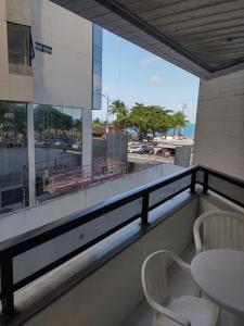 马塞约Beira Mar da Pajuçara的阳台配有桌椅,享有海景。