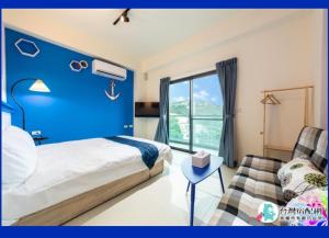 宜蘭曼曼玩民宿的一间卧室设有蓝色的墙壁、一张床和一张沙发