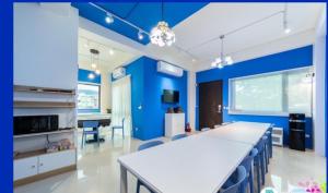 宜蘭曼曼玩民宿的厨房拥有蓝色的墙壁,配有桌椅