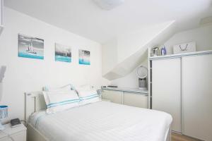 巴黎ParisMyHome - Air-conditioned, 2 shower rooms, 2 toilets的一间白色的卧室,配有床和楼梯