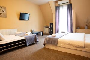 第比利斯大使酒店的一间卧室设有两张床,墙上配有电视。