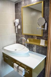 坎帕拉Arcadia Suites - Kampala的一间带水槽和镜子的浴室