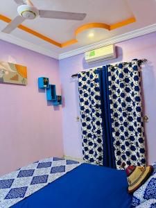 瓦加杜古Passion housse service的一间卧室配有蓝色的床和窗帘