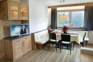 圣克里斯蒂娜Apartments La Mana的厨房以及带桌子和电视的用餐室。