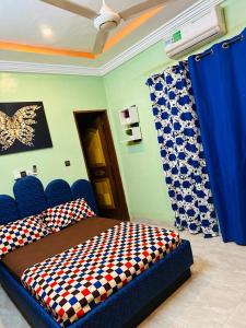 瓦加杜古Passion housse service的一间卧室配有一张带蓝色椅子和蓝色窗帘的床