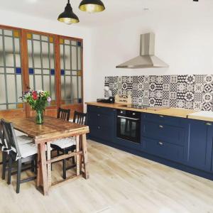 Saint-PrivatGîte de l'atelier的厨房配有木桌和蓝色橱柜。